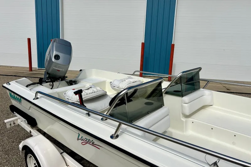 Slide: The Image of 1995 Wahoo 1650 boat with outboard motor, white interior, and windshield, parked on trailer. - 27