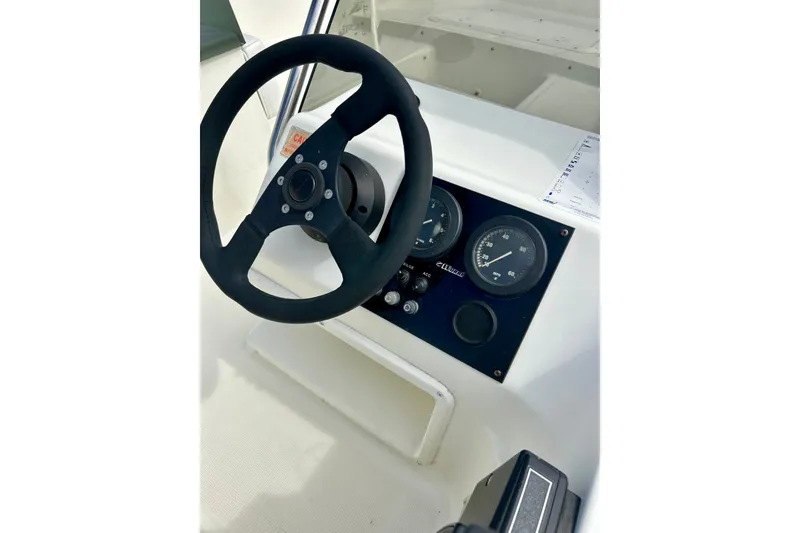 Slide: The Image of Steering wheel and dashboard of a 1995 Wahoo 1650 boat. - 15