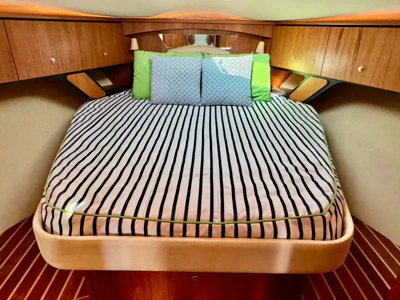 Slide: The Image of The 2006 Tiara Yachts 4300 Sovran cabin features a cozy bed with striped bedding. - 4