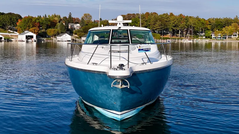 Slide: The Image of The 2006 Tiara Yachts 4300 Sovran sits calmly on a lake, surrounded by autumn trees. - 11