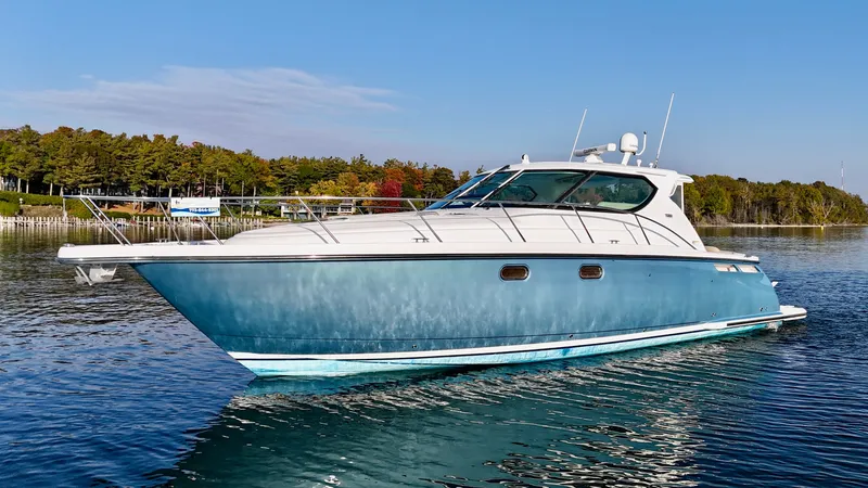 Slide: The Image of 2006 Tiara Yachts 4300 Sovran on calm water with a wooded shoreline in the background. - 12