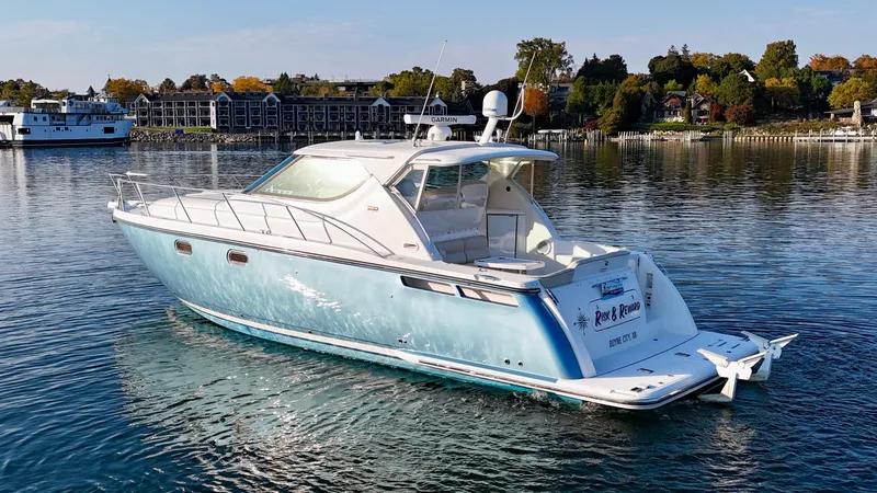 Slide: The Image of A 2006 Tiara Yachts 4300 Sovran on calm water, surrounded by autumn trees. - 16