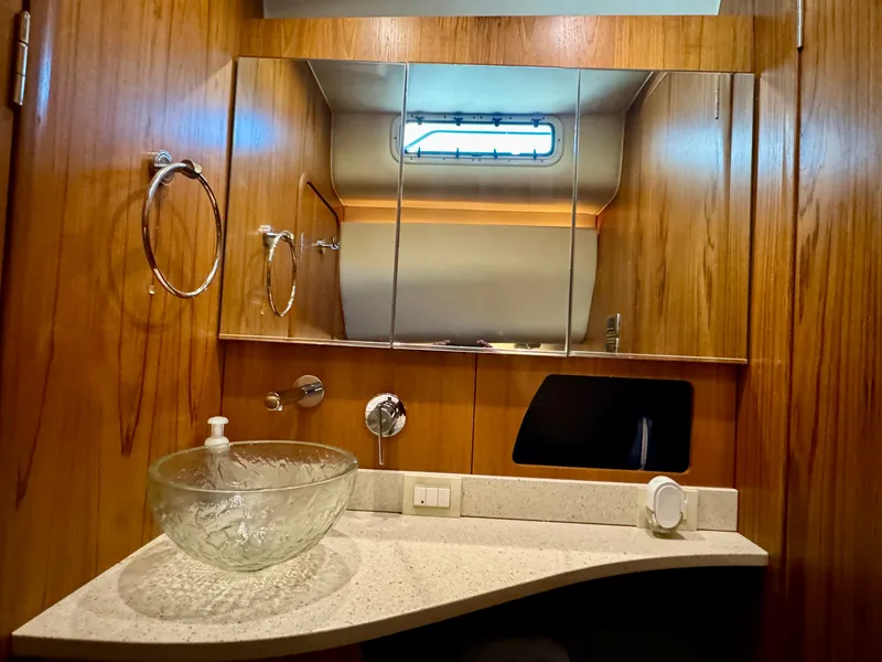 Slide: The Image of The image shows an elegant bathroom with wood paneling, a glass sink, and a small window. - 48