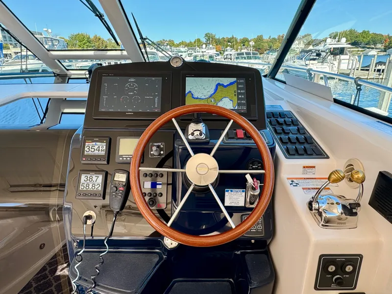 Slide: The Image of The cockpit of a 2006 Tiara Yachts 4300 Sovran with a wooden steering wheel and modern instruments. - 28
