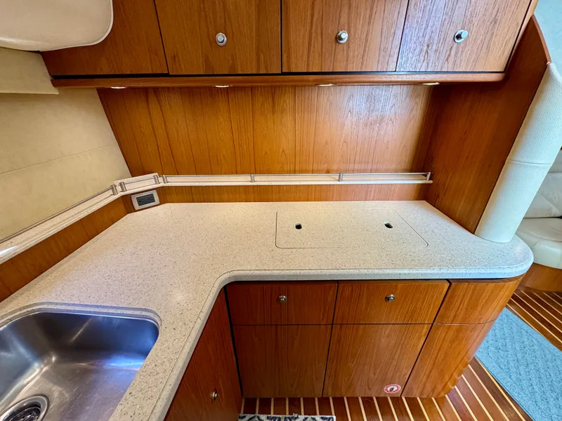 Slide: The Image of The 2006 Tiara Yachts 4300 Sovran galley features wooden cabinets and a countertop. - 42
