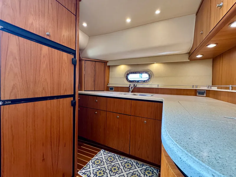 Slide: The Image of The 2006 Tiara Yachts 4300 Sovran galley features wood cabinets and a countertop. - 39