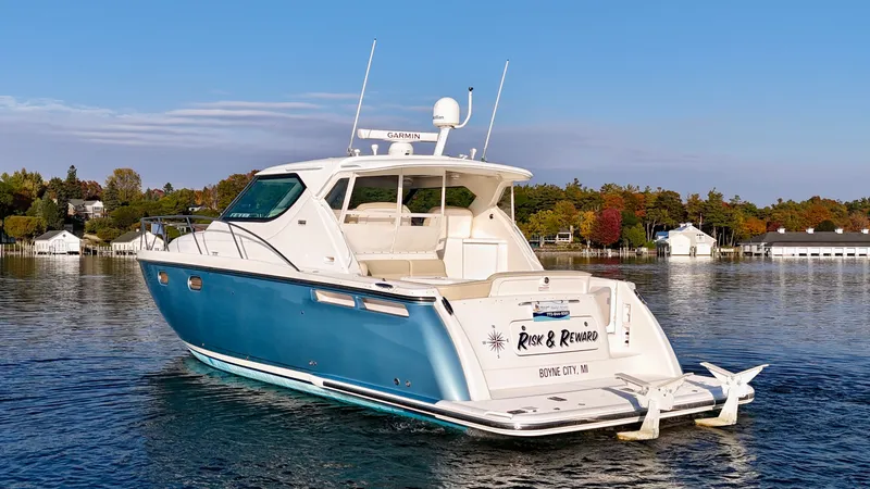 Slide: The Image of 2006 Tiara Yachts 4300 Sovran on calm water, surrounded by autumn trees and houses. - 6