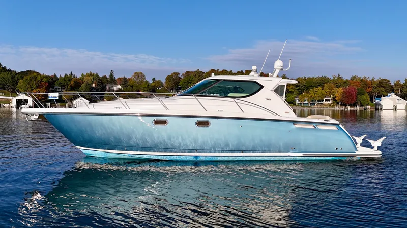 Slide: The Image of A 2006 Tiara Yachts 4300 Sovran on calm water, surrounded by autumn trees. - 5