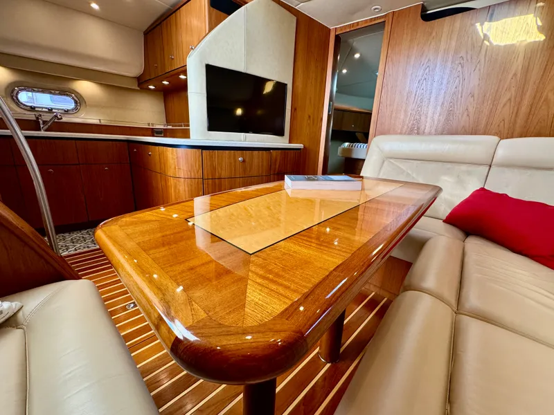 Slide: The Image of Interior of a 2006 Tiara Yachts 4300 Sovran with a wooden table and leather sofas. - 3