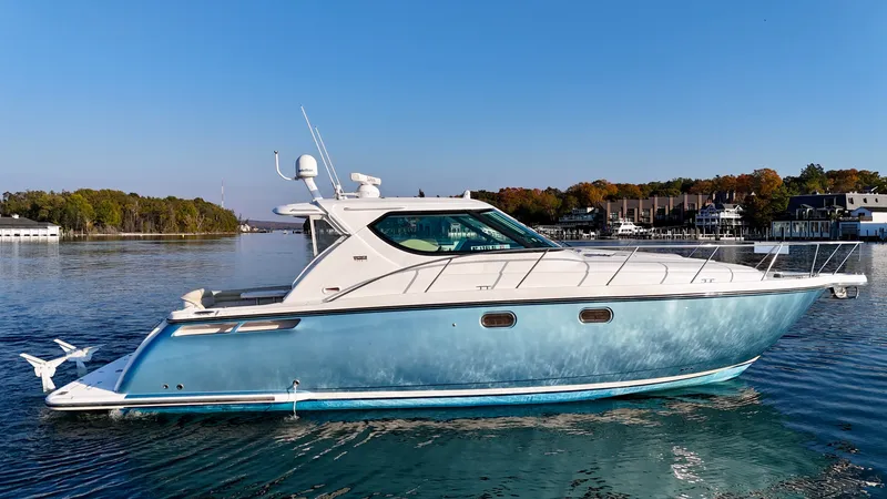 Slide: The Image of A 2006 Tiara Yachts 4300 Sovran on calm water with a wooded shoreline in the background. - 9