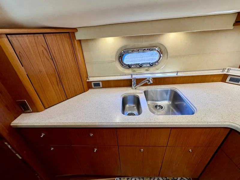 Slide: The Image of The 2006 Tiara Yachts 4300 Sovran galley features a sink and wooden cabinetry. - 41