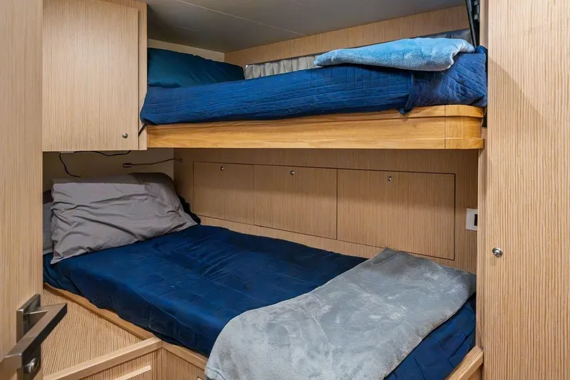 Slide: The Image of Bunk beds in a 2022 Ferretti 850 yacht cabin with blue bedding. - 61