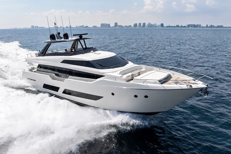 Slide: The Image of 2022 Ferretti 850 yacht cruising on open sea with city skyline in background. - 70
