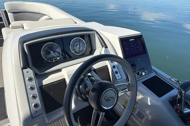 Slide: The Image of 2023 Barletta CORSA 23QSS boat dashboard with steering wheel and digital display on calm water. - 10