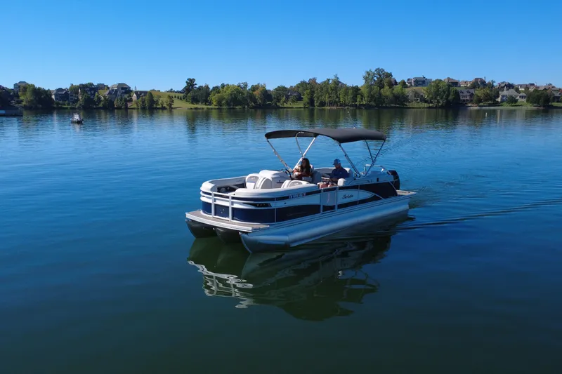 Slide: The Image of 2023 Barletta CORSA 23QSS pontoon boat cruising on a serene lake. - 1