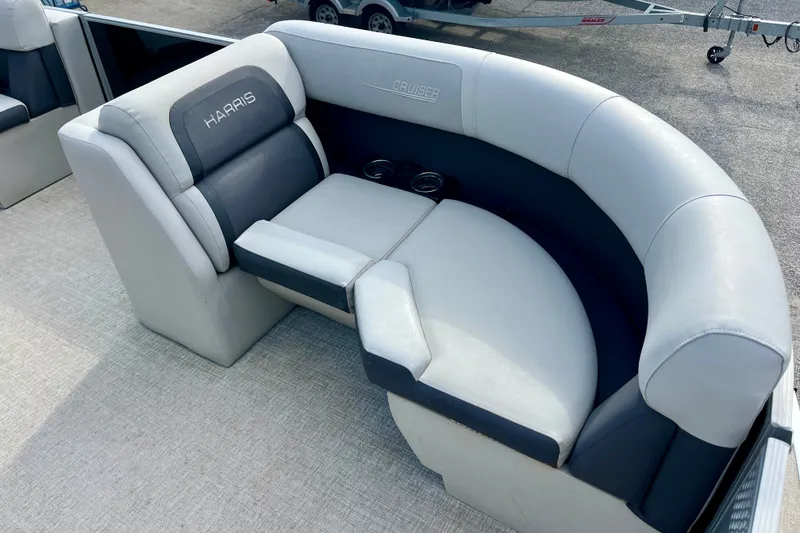 Slide: The Image of 2024 Harris Cruiser 230 boat seating with gray upholstery and cup holders. - 2
