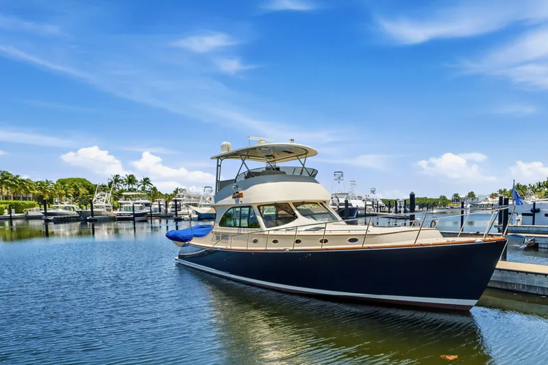 The Image of 2007 Hinckley Talaria 55 yacht docked in a sunny marina, surrounded by palm trees. - 0