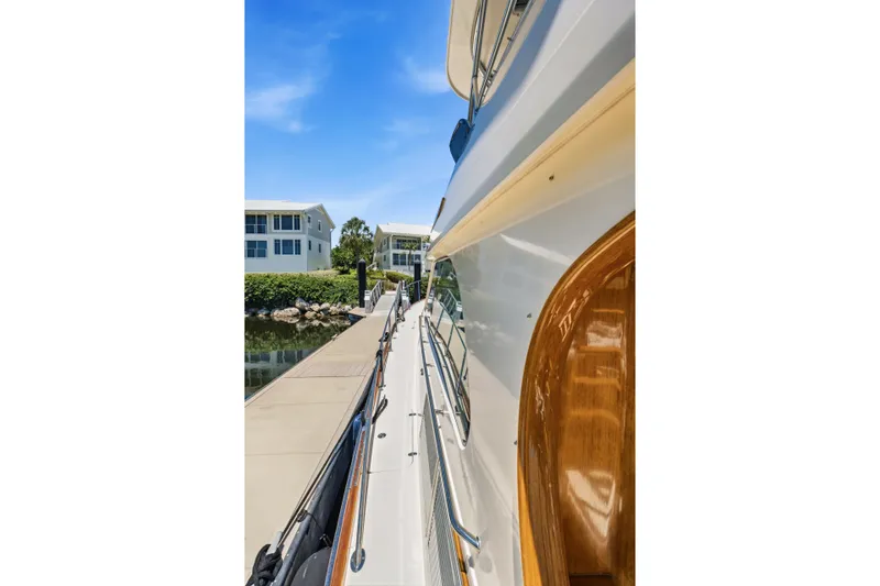 Slide: The Image of Side view of a 2007 Hinckley Talaria 55 yacht docked near waterfront homes. - 55