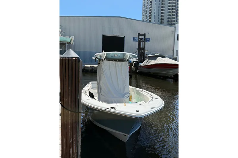 Slide: The Image of 2024 Sea Hunt Ultra 234 boat docked at marina, covered and ready for use. - 16