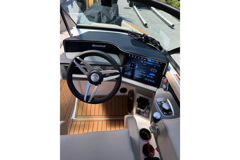 Slide: The Image of 2027 MasterCraft XT23 boat dashboard with modern steering wheel and digital display. - 1
