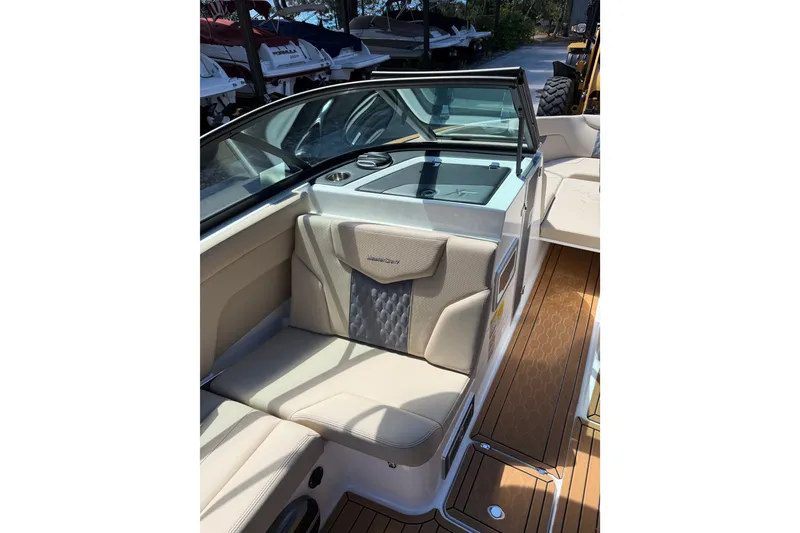 Slide: The Image of 2027 MasterCraft XT23 boat interior with beige seating and teak flooring. - 3