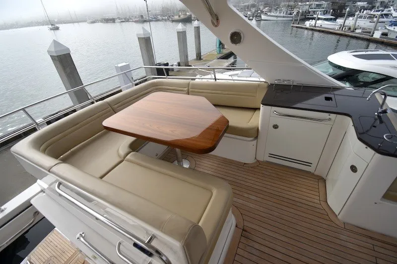 Slide: The Image of Luxurious 2015 Sea Ray 510 Fly yacht deck with seating and table, docked at marina. - 25
