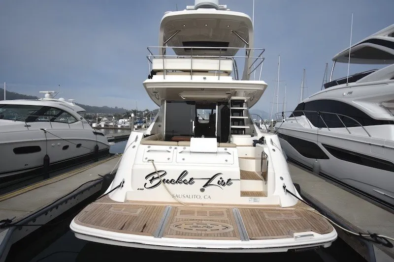 Slide: The Image of 2015 Sea Ray 510 Fly yacht docked, rear view, featuring spacious deck and elegant design. - 40