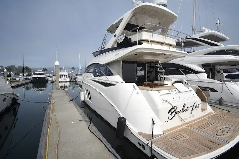 Slide: The Image of 2015 Sea Ray 510 Fly yacht docked at marina, showcasing elegant design and spacious deck. - 41