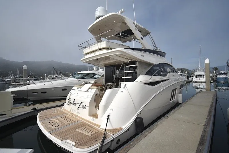 Slide: The Image of 2015 Sea Ray 510 Fly yacht docked at marina, showcasing elegant design and spacious flybridge. - 42
