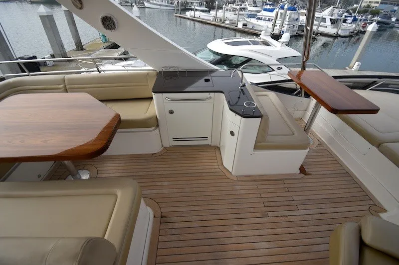 Slide: The Image of Luxurious 2015 Sea Ray 510 Fly yacht deck with seating, tables, and marina view. - 27