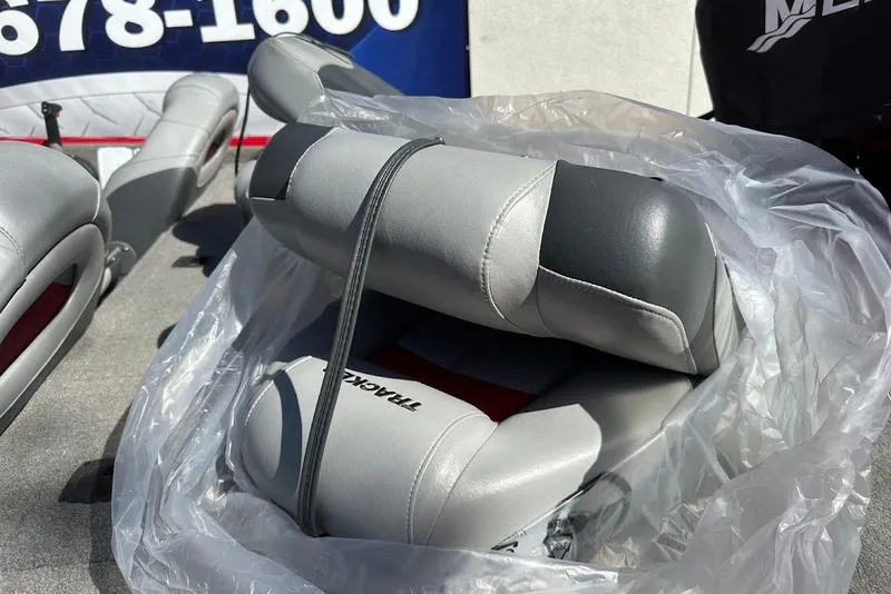 Slide: The Image of 2012 Tracker Pro Team 175 TXW boat seats wrapped in plastic, displayed outdoors. - 27