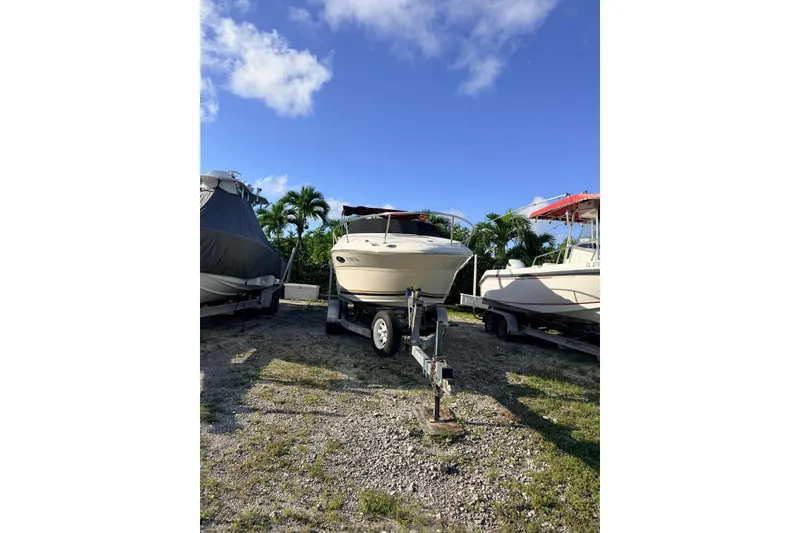 Slide: The Image of 2002 Sea Ray 225 Weekender boat on trailer under clear blue sky. - 5