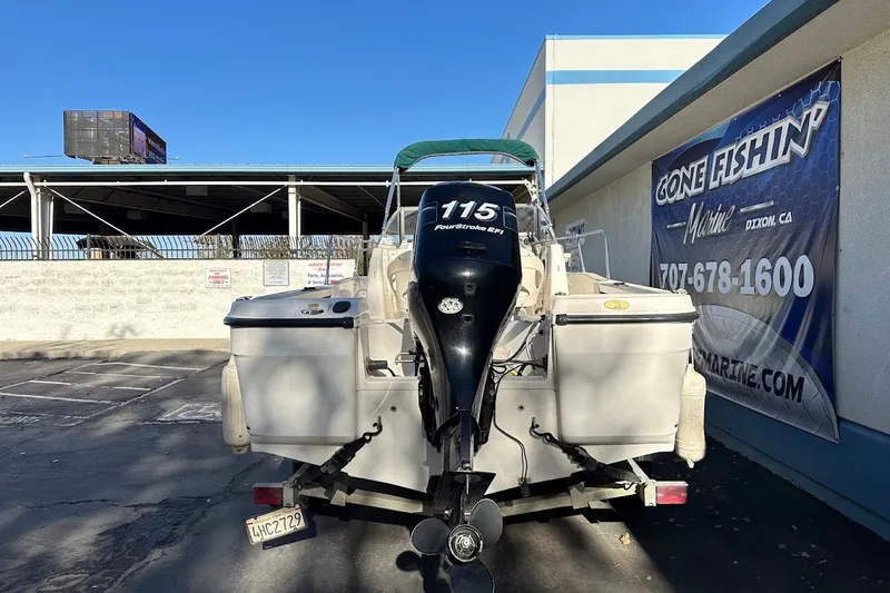 Slide: The Image of 2005 Trophy 1802 Walkaround boat with outboard motor, parked near marine shop. - 6