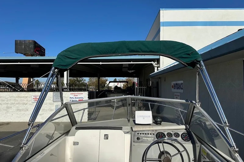 Slide: The Image of 2005 Trophy 1802 Walkaround boat with green canopy and dashboard view. - 30