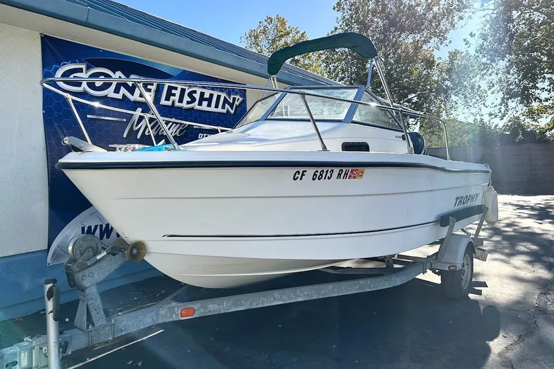 Slide: The Image of 2005 Trophy 1802 Walkaround boat on trailer, parked outdoors in sunny weather. - 2