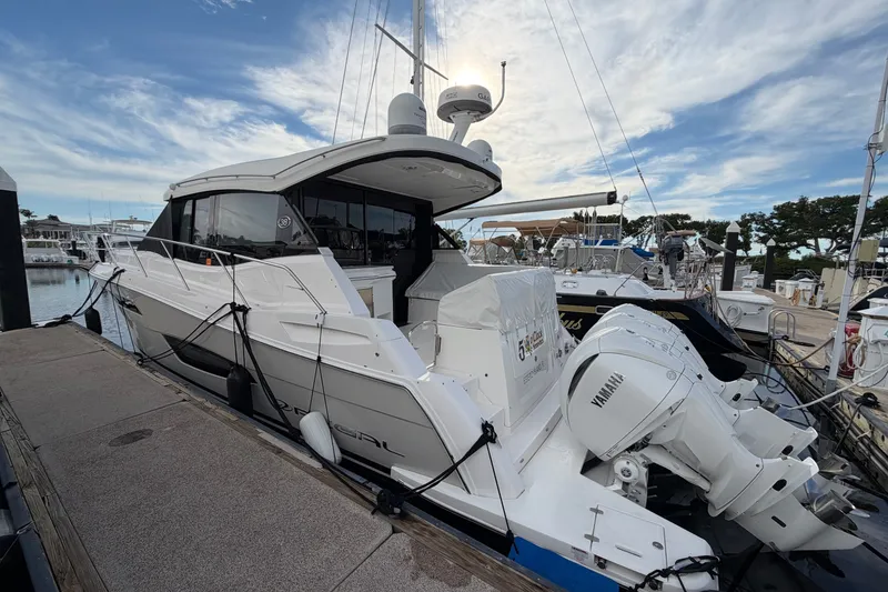 The Image of 2022 Regal 38 XO yacht docked with Yamaha engines, under a partly cloudy sky. - 0