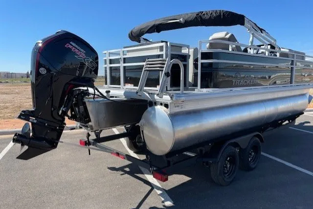 The Image of 2027 Sun Tracker Fishin' Barge 20 DLX pontoon boat with outboard motor in parking lot. - 0