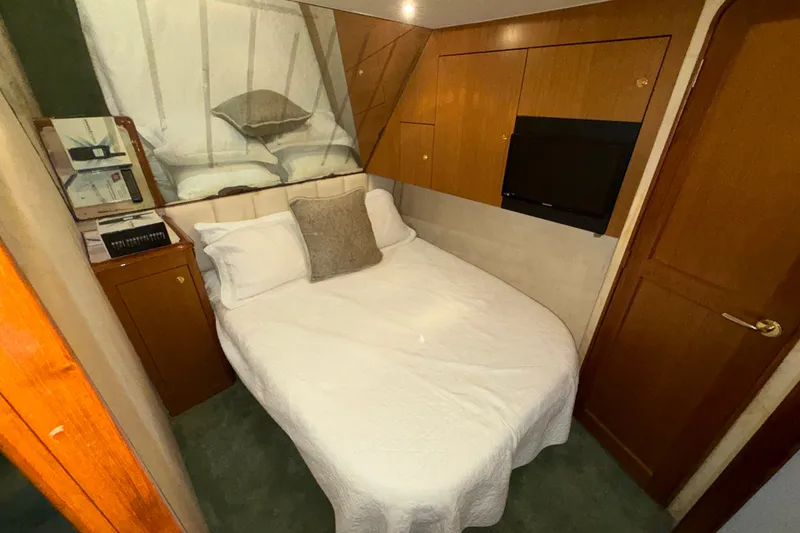 Slide: The Image of Cozy bedroom in 2001 Ocean Yachts 48 Super Sport with wood accents and TV. - 43