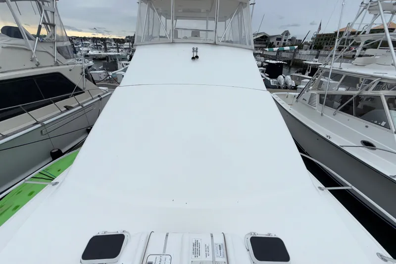 Slide: The Image of 2001 Ocean Yachts 48 Super Sport docked at marina, surrounded by other boats. - 56