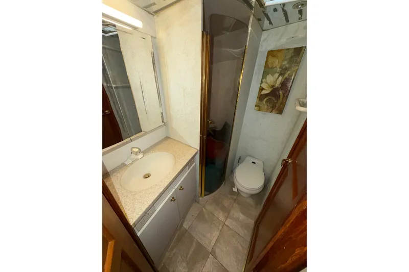 Slide: The Image of Bathroom interior of 2001 Ocean Yachts 48 Super Sport, featuring sink, toilet, and shower. - 48