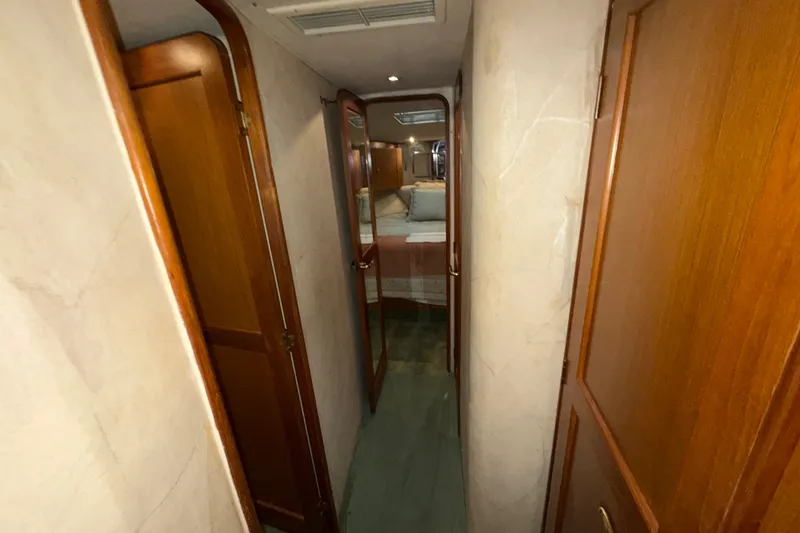Slide: The Image of Narrow hallway inside 2001 Ocean Yachts 48 Super Sport, featuring wooden doors and cozy interior. - 49