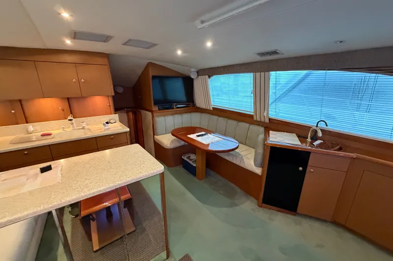 Slide: The Image of Luxurious interior of 2001 Ocean Yachts 48 Super Sport with kitchen and seating area. - 34