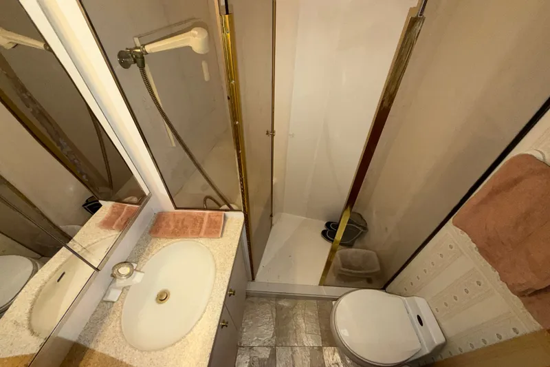Slide: The Image of Bathroom interior of 2001 Ocean Yachts 48 Super Sport, featuring shower, sink, and toilet. - 47
