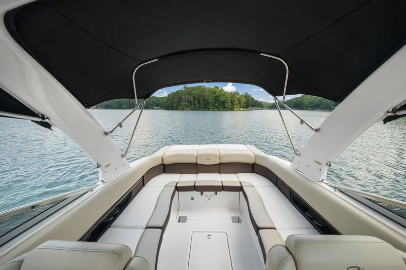 Slide: The Image of 2015 Regal 2700 ES Bowrider interior with lake view, featuring spacious seating and canopy. - 15