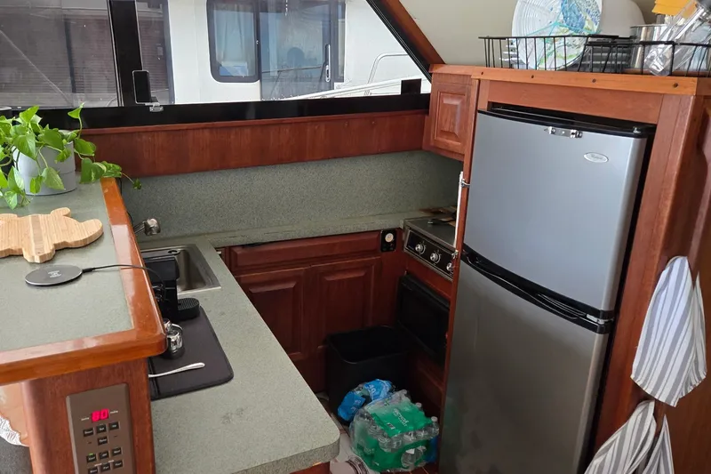 Slide: The Image of 1989 Viking 45 Convertible yacht kitchen with modern appliances and wooden cabinetry. - 23