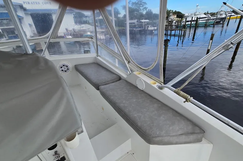Slide: The Image of 1989 Viking 45 Convertible boat interior with cushioned seating and marina view. - 8