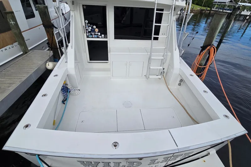 Slide: The Image of 1989 Viking 45 Convertible boat docked, featuring spacious deck and ladder access. - 3