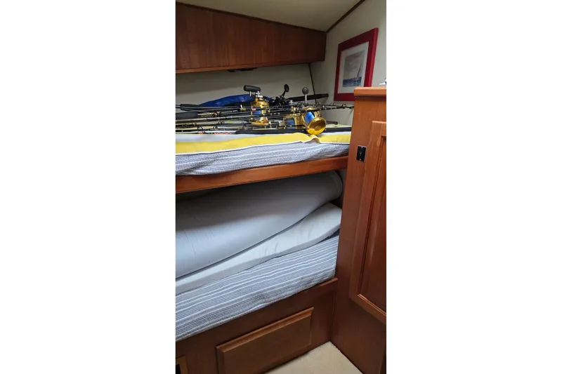 Slide: The Image of Bunk beds with fishing rods in a 1989 Viking 45 Convertible boat cabin. - 25