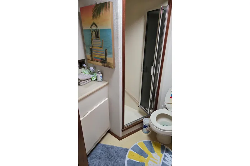 Slide: The Image of Bathroom interior of 1989 Viking 45 Convertible yacht with shower and beach-themed decor. - 27