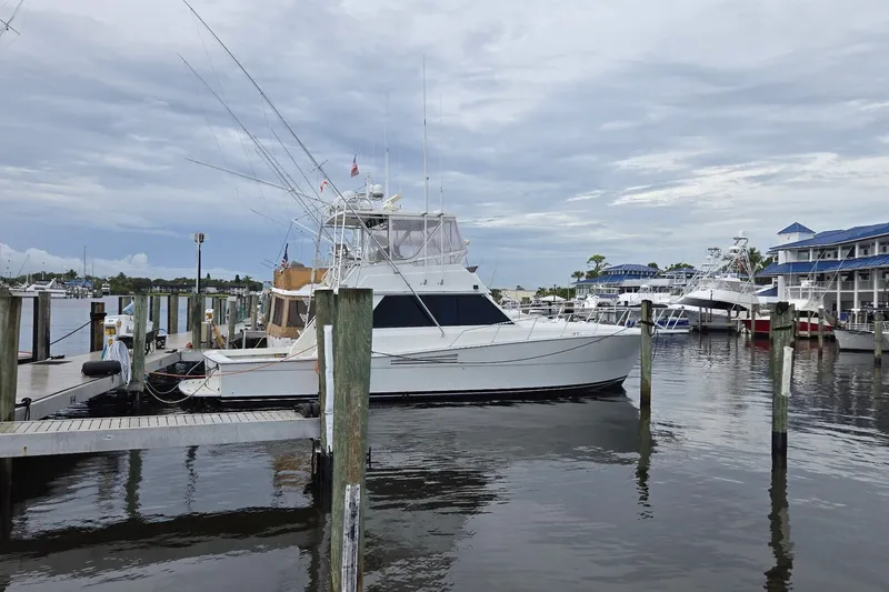 Slide: The Image of 1989 Viking 45 Convertible yacht docked at a marina under cloudy skies. - 1